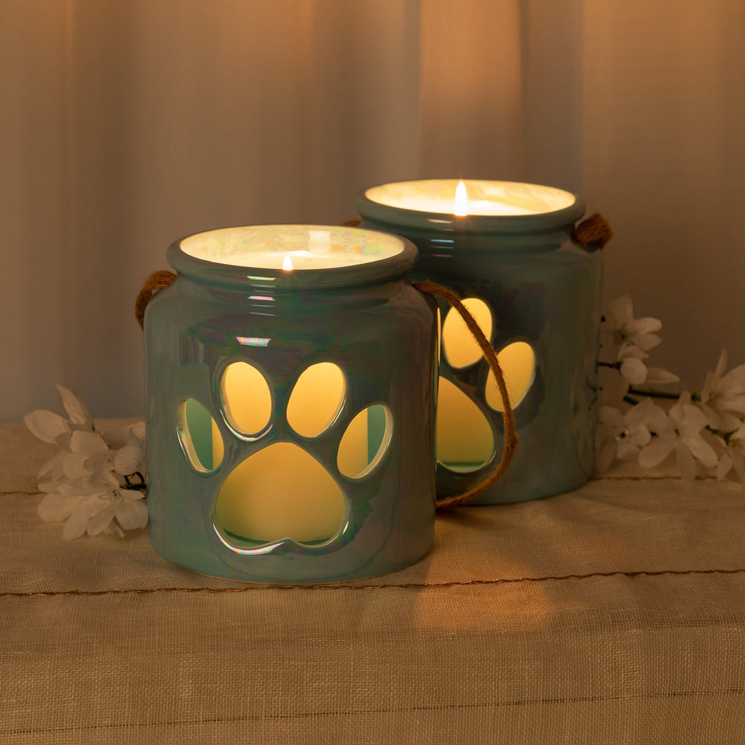 Blue paw-print glass candle holders, lit candles on top, with rope handles