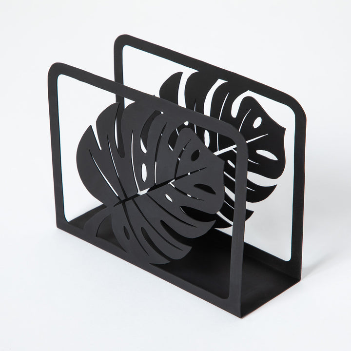 Black metal napkin holder angled view with framed monstera leaf cutout