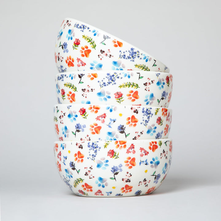 Stacked ceramic soup bowls with multicolor paw-and-flower pattern