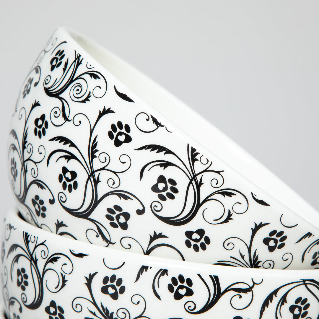 Ceramic bowl rim with black paw-print and swirl pattern