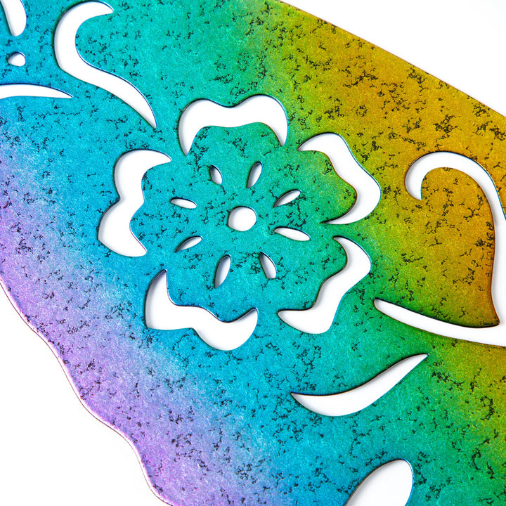 Close-up of iridescent green and gold metal hummingbird silhouette with white leaf cutout