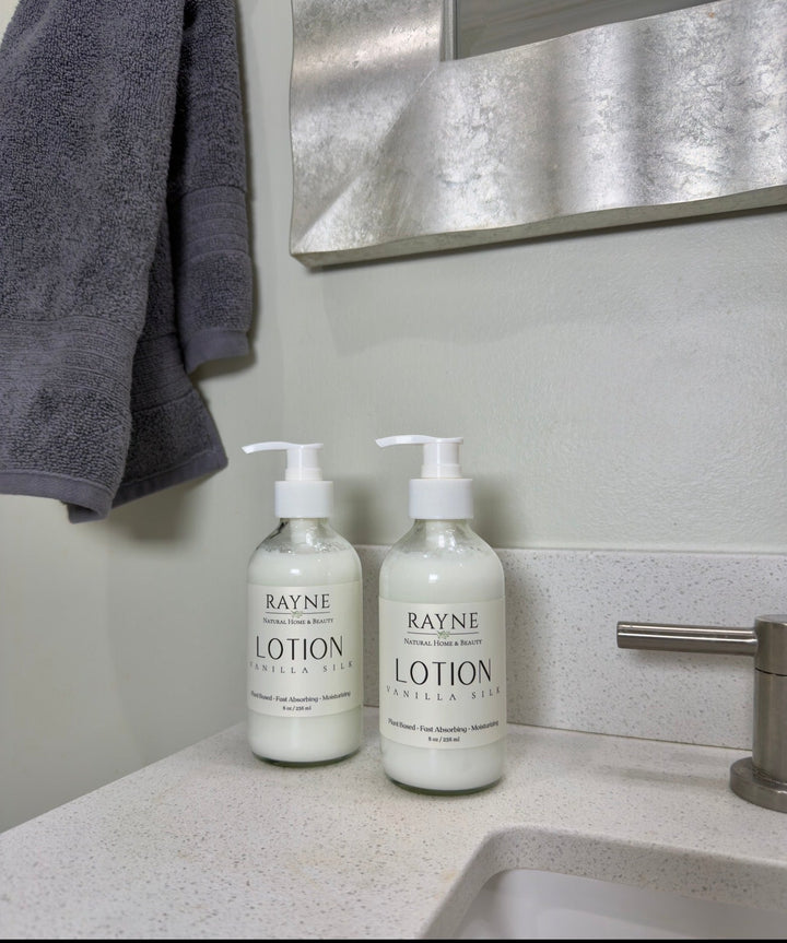 Two cream Rayne body lotion bottles with white pumps on bathroom counter