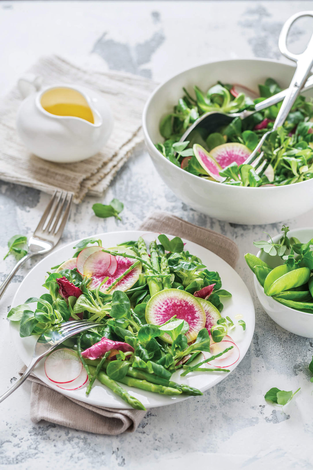 White round dinner plate with smooth rim, shown with salad on top.