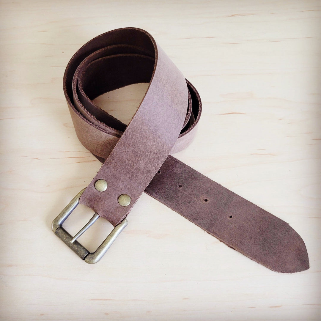 Distressed brown leather belt with metal buckle, punched eyelets and curled straps