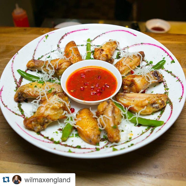 Round white porcelain dish with chicken and red dipping sauce