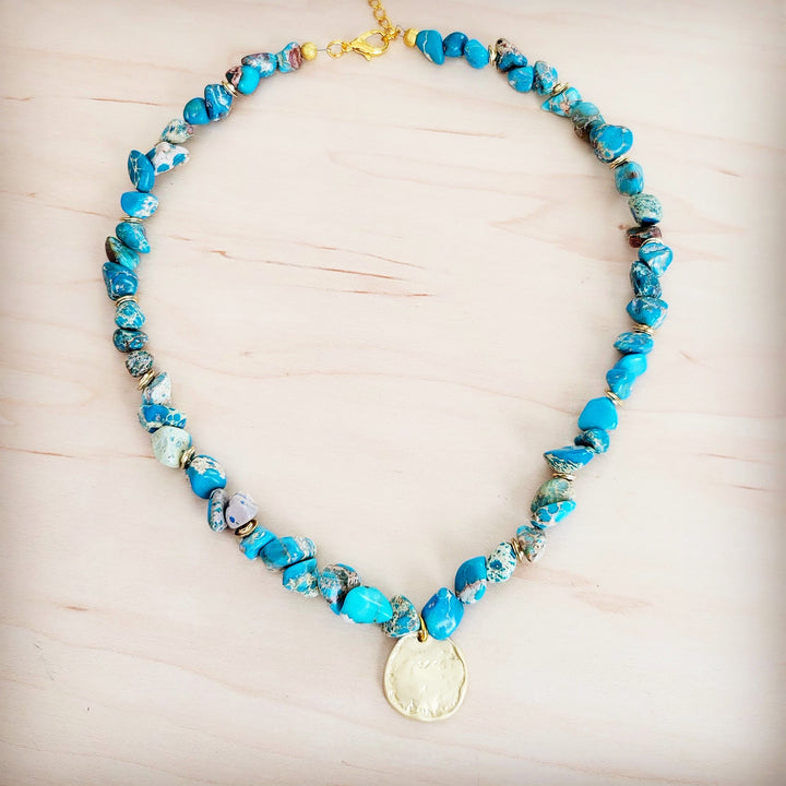 Turquoise beaded collar necklace with large round gold coin pendant at the center