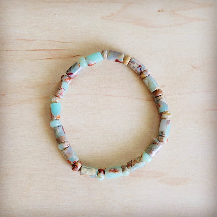 Beaded stretch bracelet with barrel beads in turquoise, blue, and tan