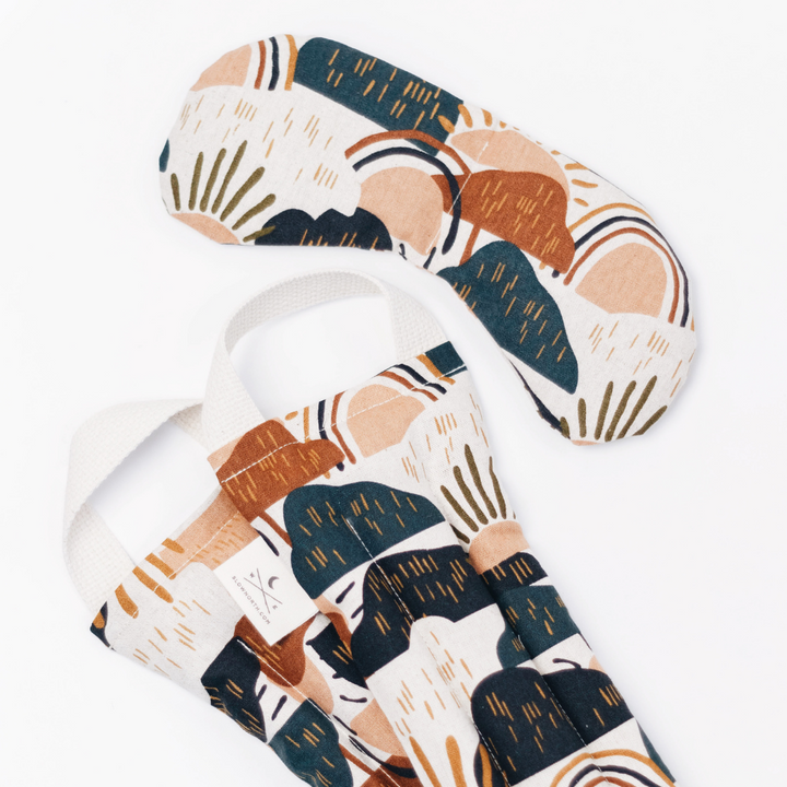 Rainbow-pattern eye mask and neck wrap laid together with fabric straps