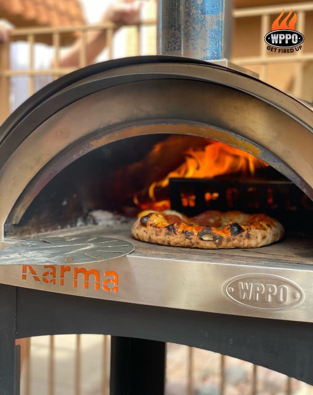 Wood-fired oven interior with pizza baking in the arched firebox
