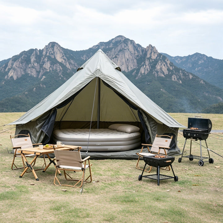 Bell tent with raised sleeping area inside and stove outside, large canopy