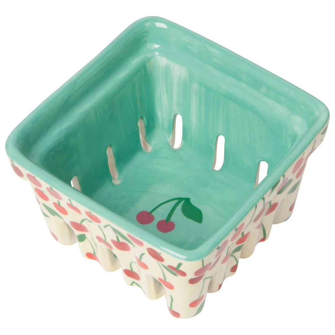 Square plastic basket with green interior, cherry print sides, four drain slots