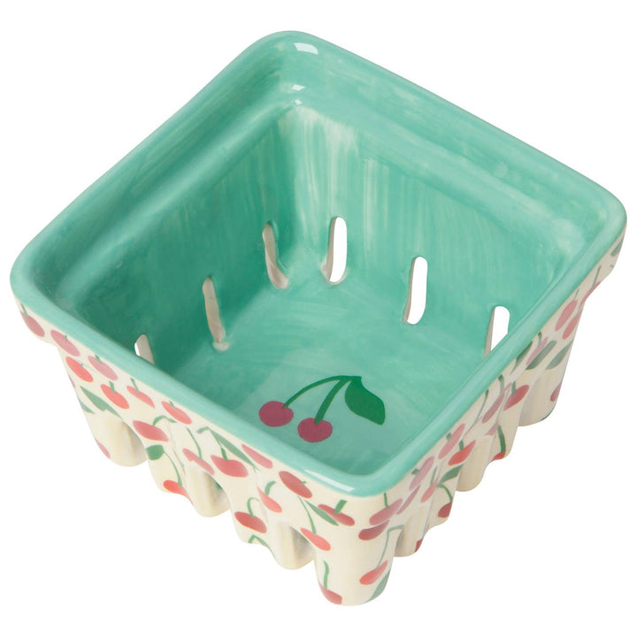 Square plastic basket with green interior, cherry print sides, four drain slots