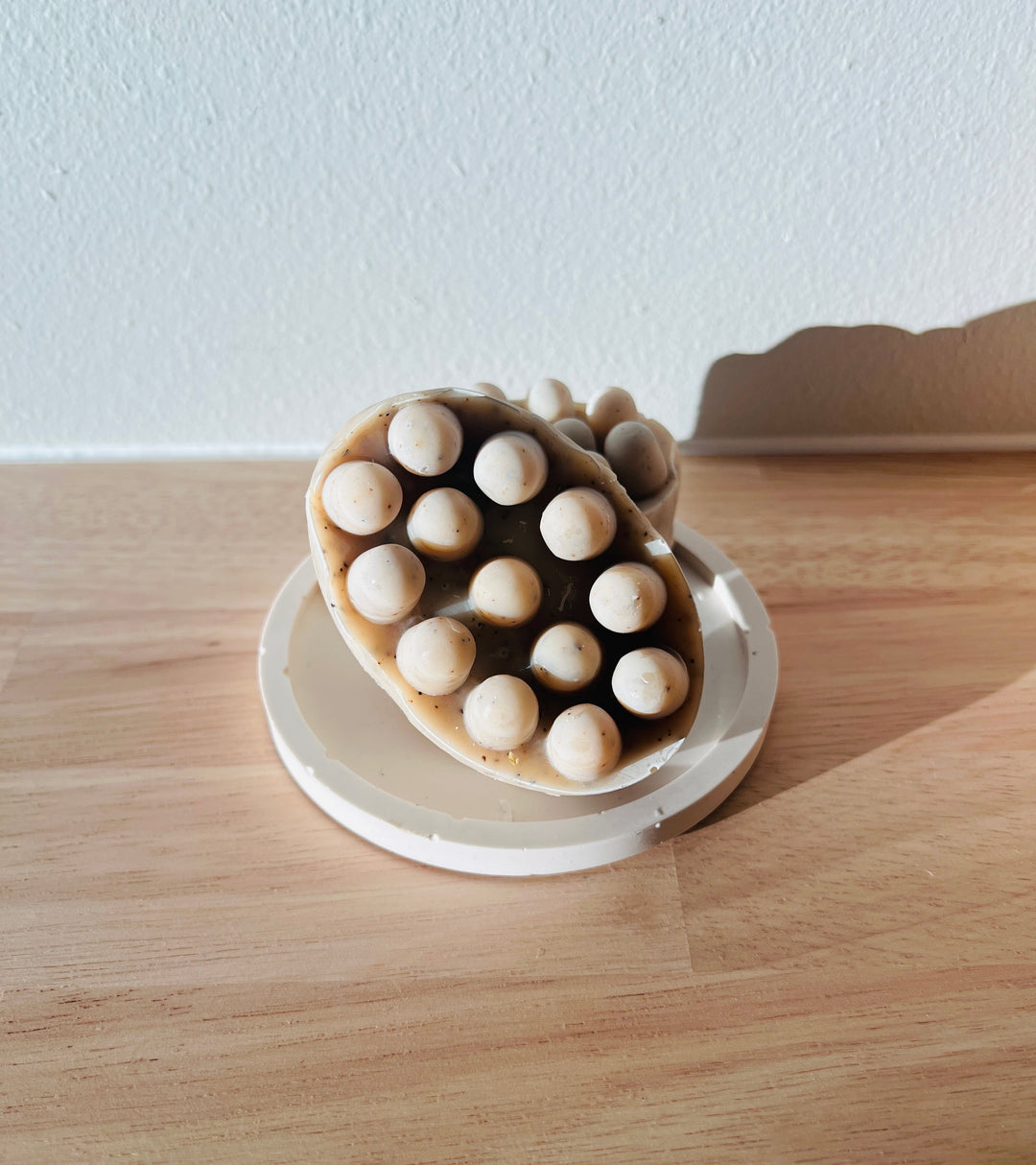 Lymphatic massage bar soap shaped with rounded nodules in a dish