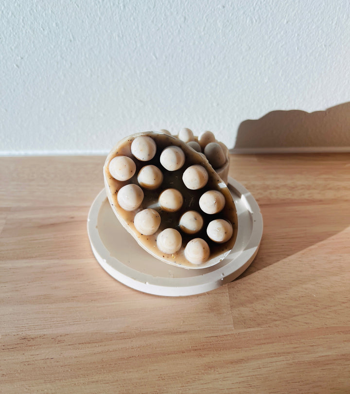 Lymphatic massage bar soap shaped with rounded nodules in a dish