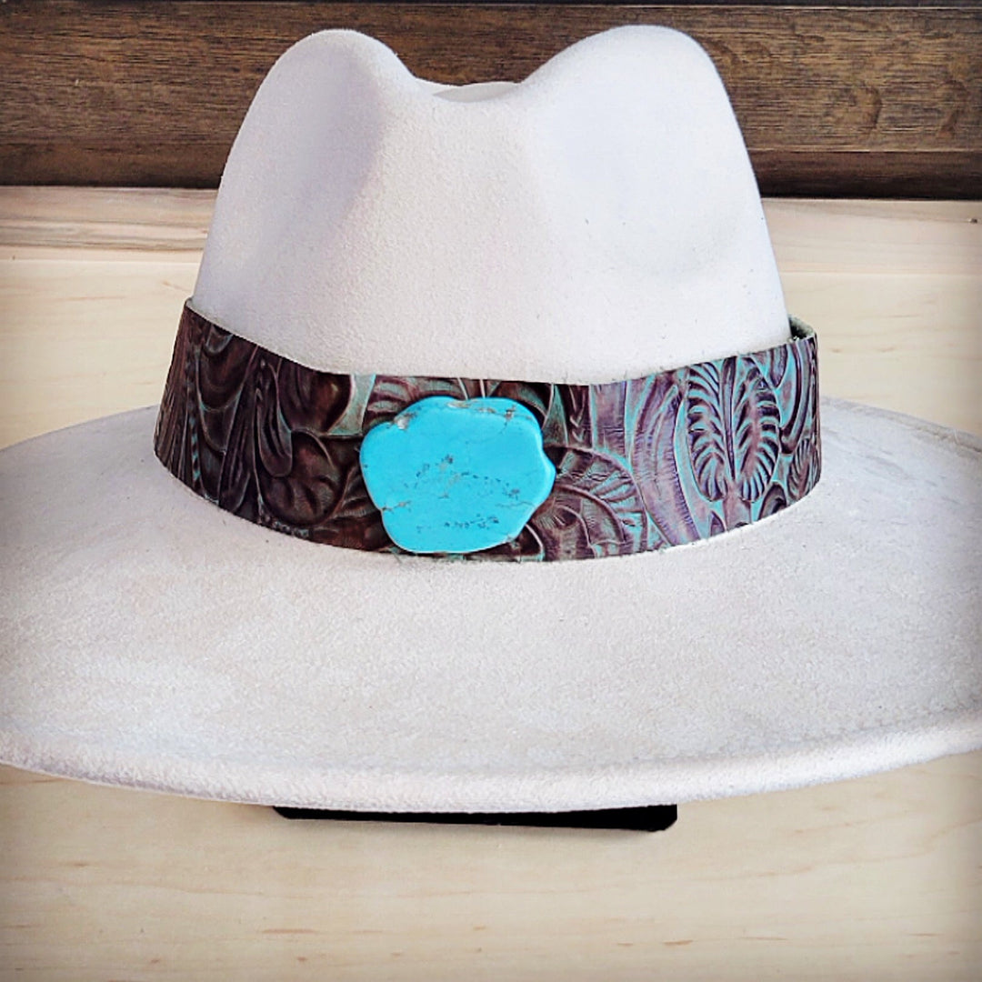 White felt wide-brim hat with brown floral leather band and turquoise round badge