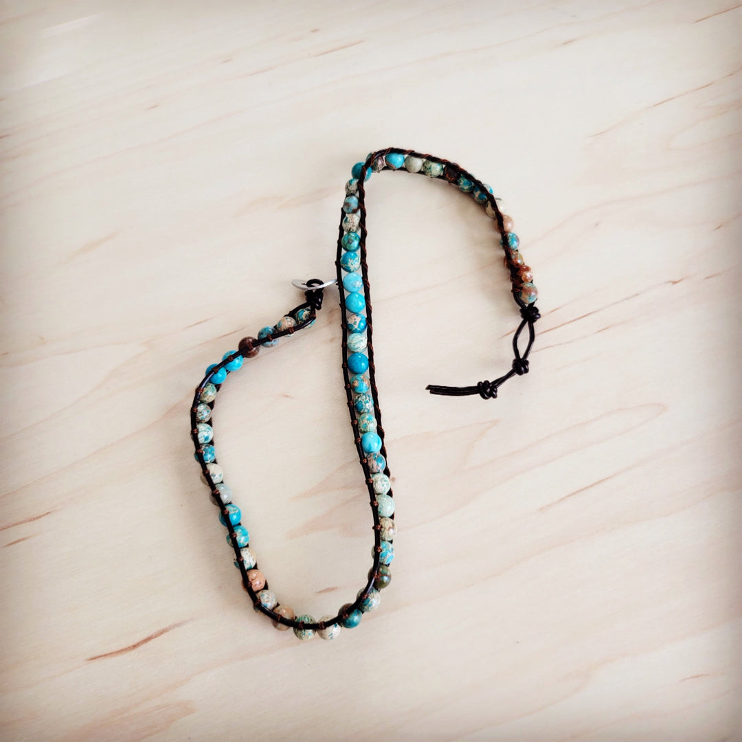 Beaded bracelet with turquoise and white beads on black cord and adjustable tie ends