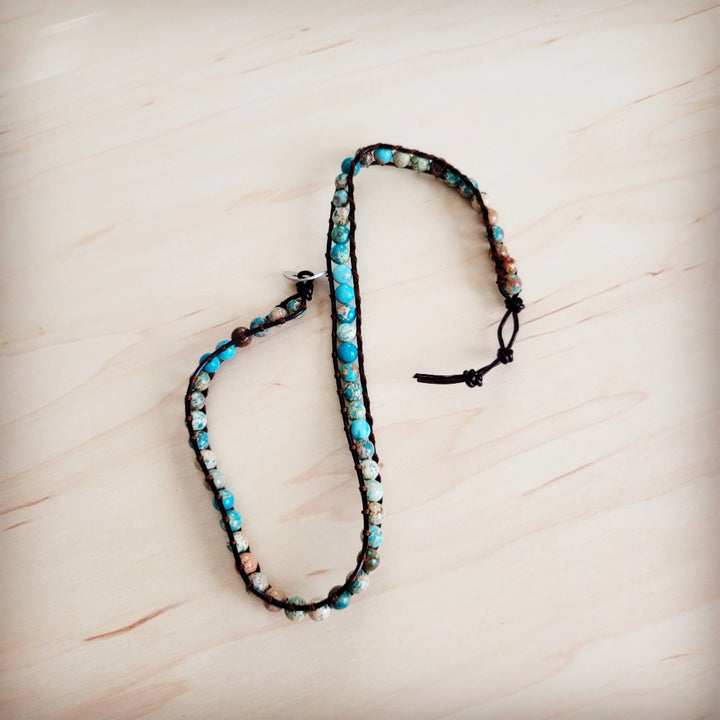 Beaded bracelet with turquoise and white beads on black cord and adjustable tie ends