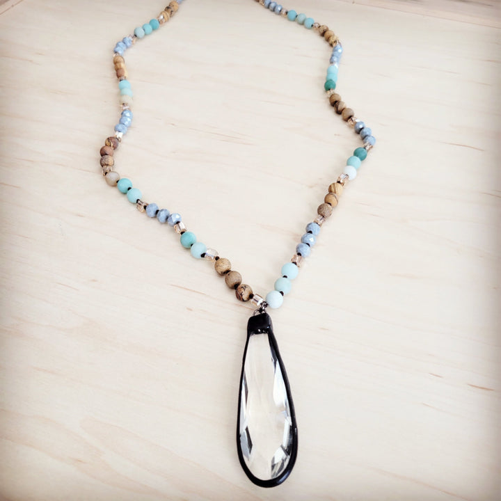 Long beaded necklace with turquoise beads and teardrop crystal pendant, side view