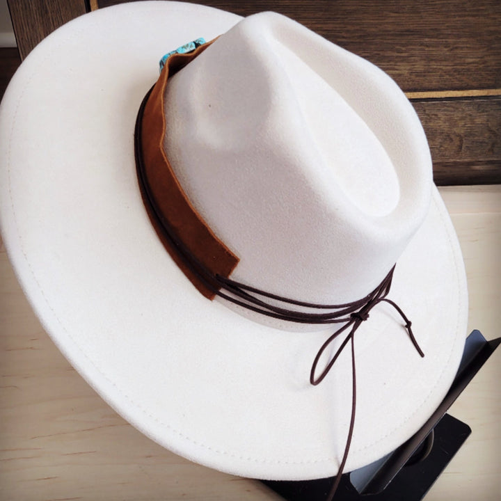 Tan suede hat band detail with turquoise patch and tied leather cords