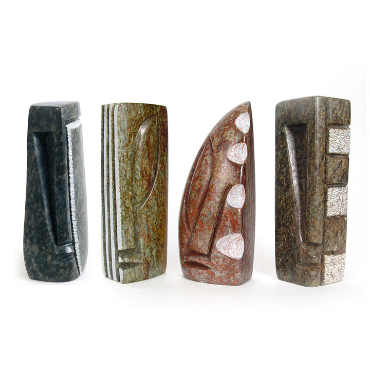 Set of four abstract stone sculptures with varied colors and white block accents