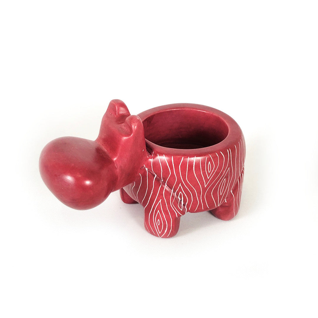 Red hippo soapstone tealight holder with patterned candle cup and open top.