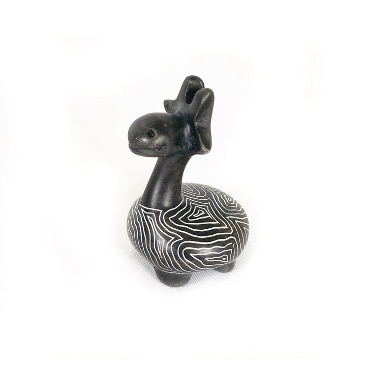 Soapstone giraffe figurine with dark body and white wavy stripe belly, facing left