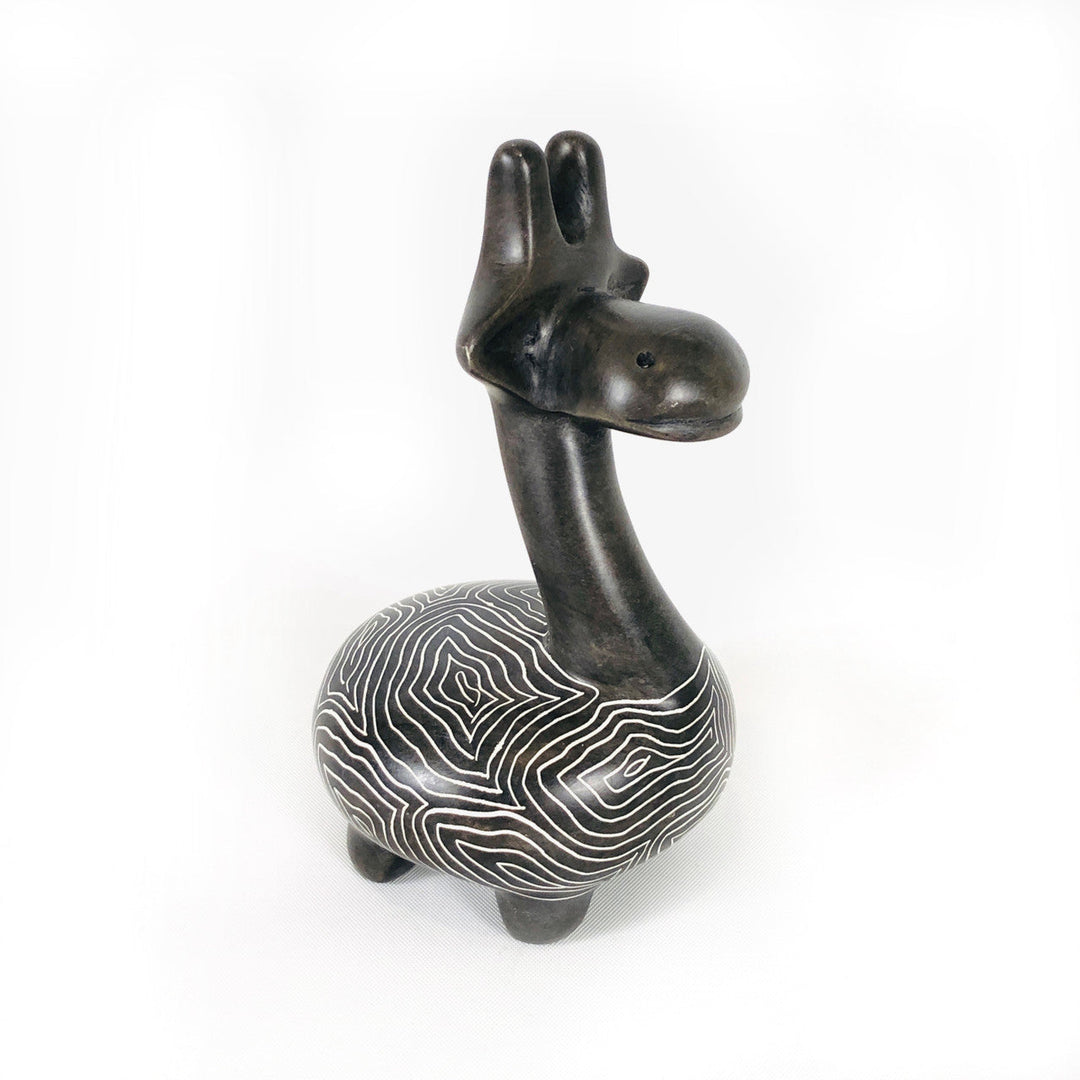 Soapstone giraffe figurine with dark head and neck and white wavy striped body, side view