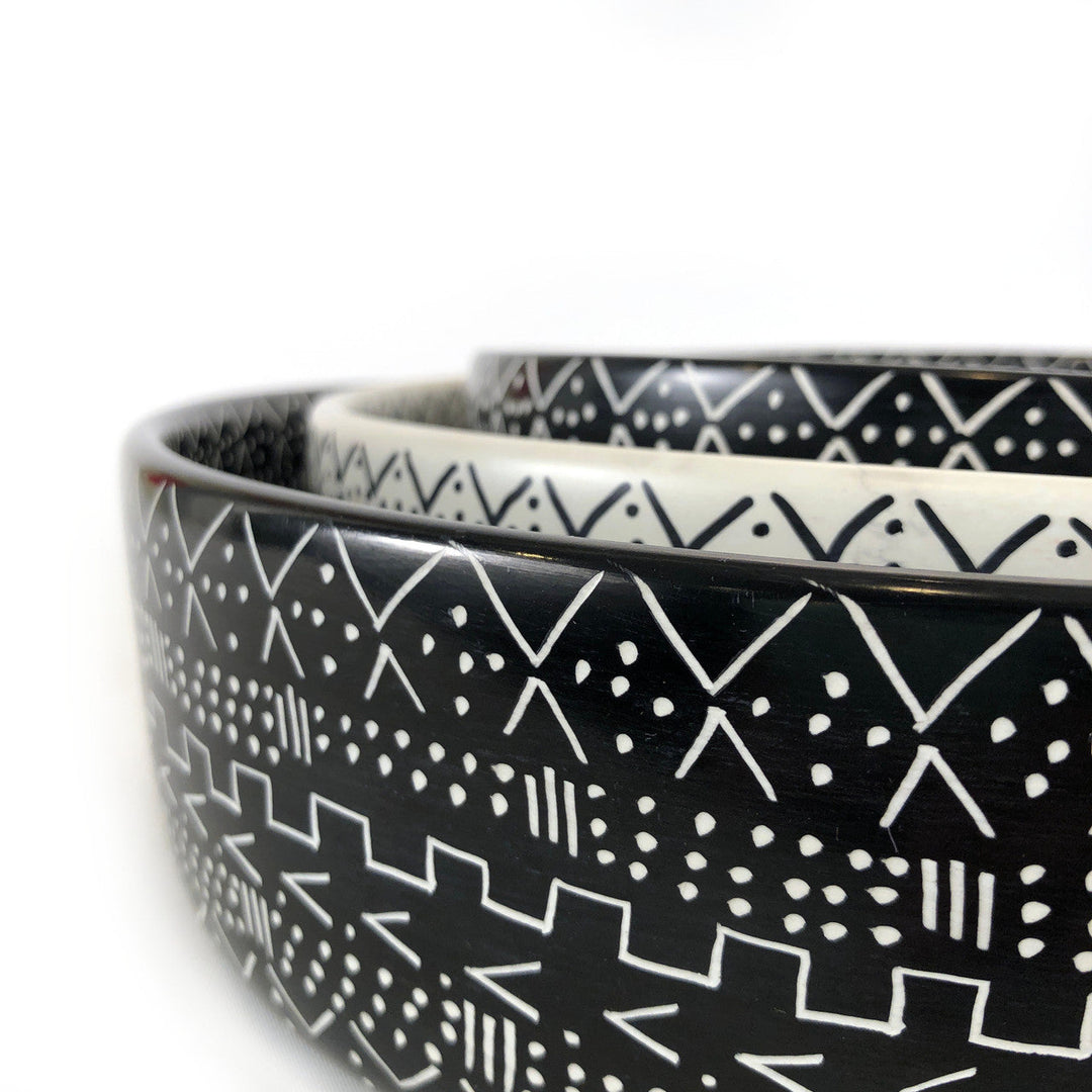 Close-up of black bowl with white geometric motifs and speckled texture
