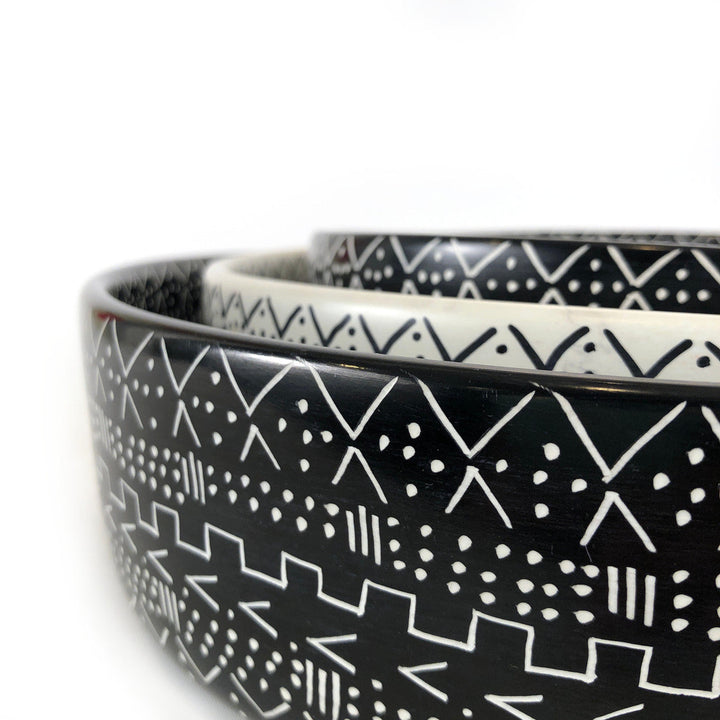 Close-up of black bowl with white geometric motifs and speckled texture