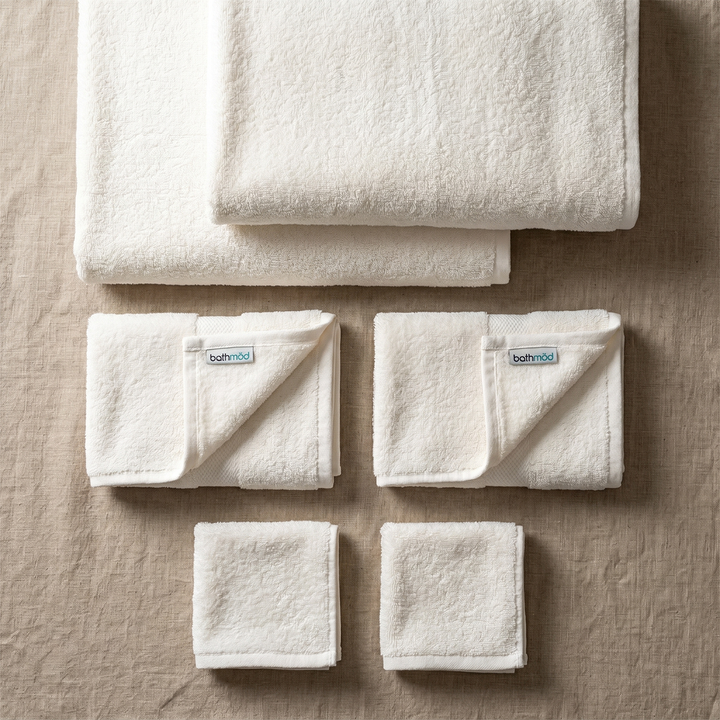 White bath towel set with six folded towels and bathmood woven labels