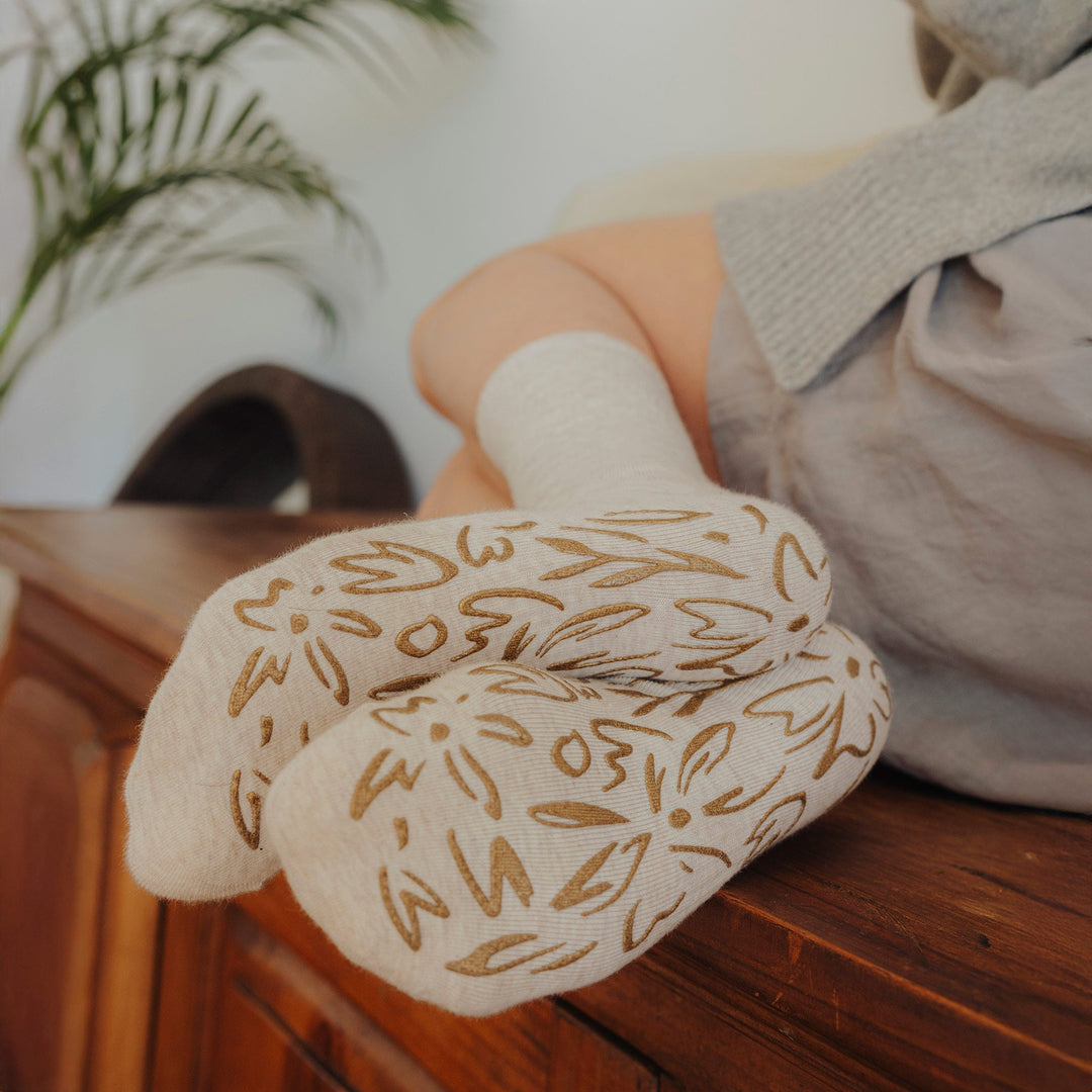Beige non-slip grip socks with brown floral pattern on the sole