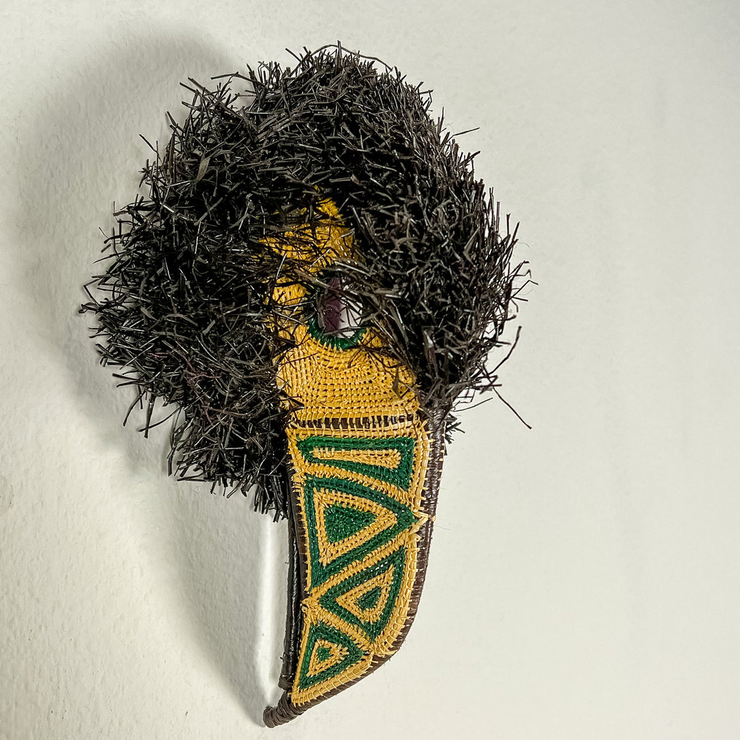 Toucan-shaped mask with black shag, teal eye patch, yellow face panel, and beak