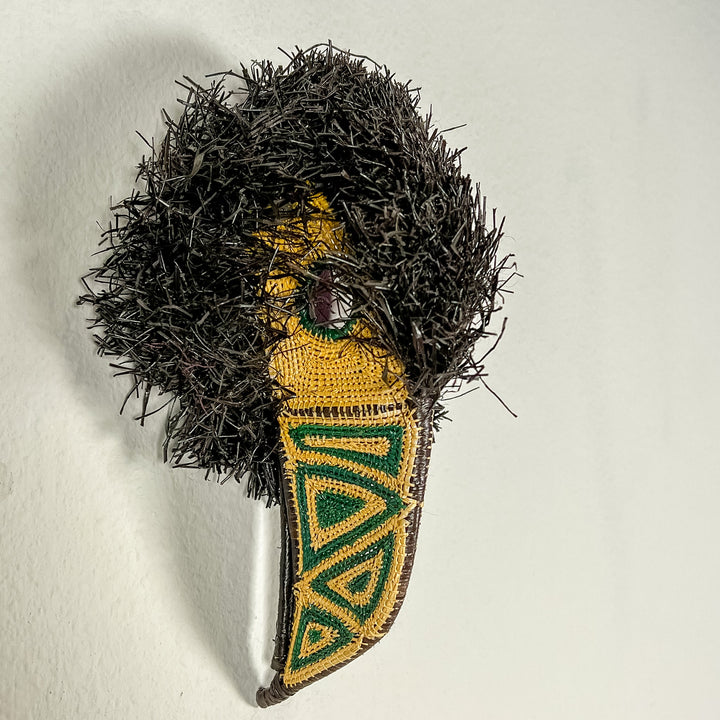 Toucan-shaped mask with black shag, teal eye patch, yellow face panel, and beak
