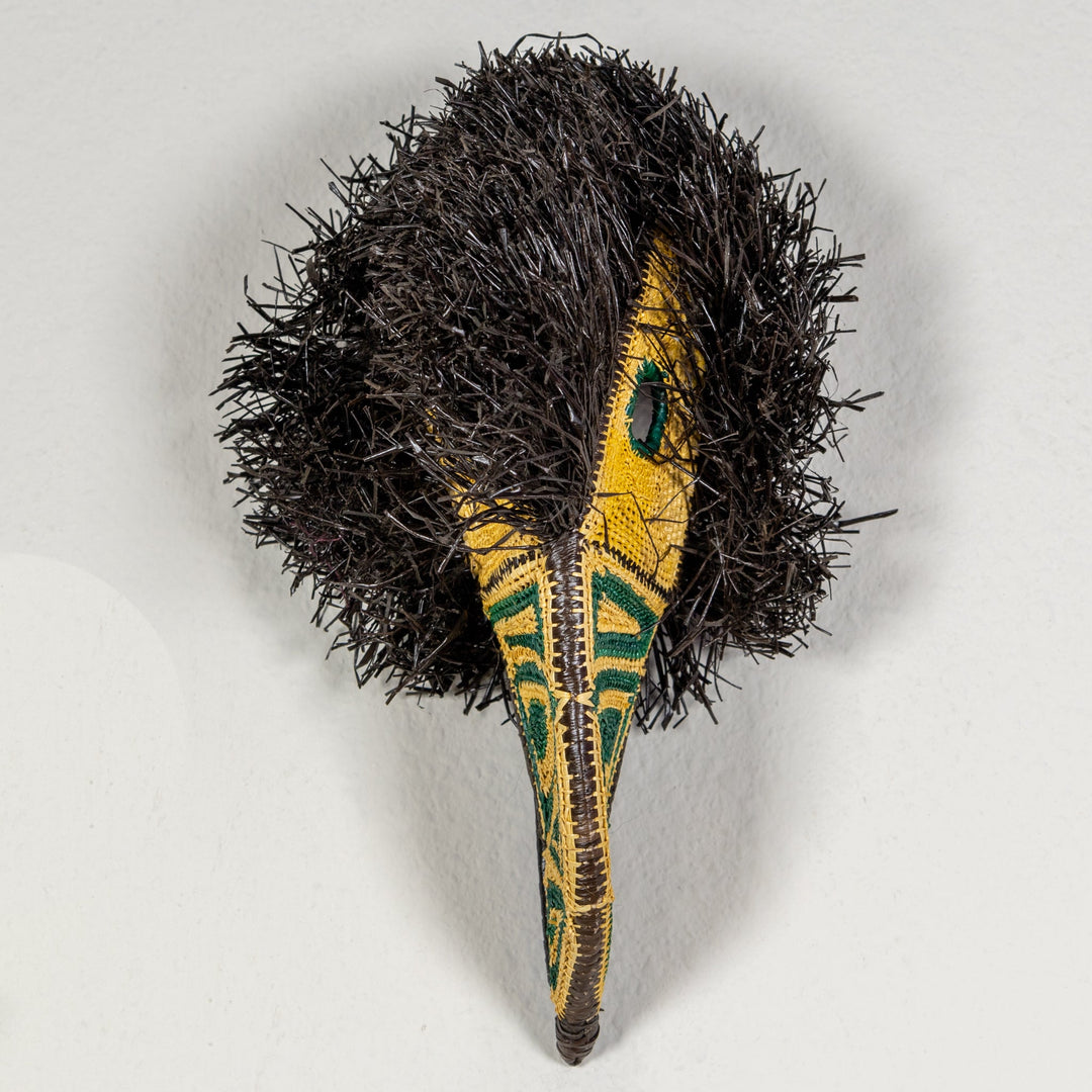Toucan mask from above with black shag body and yellow beak with green accents