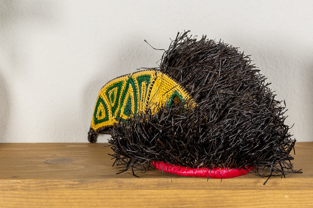 Black fringed toucan mask with yellow face panel and red underside