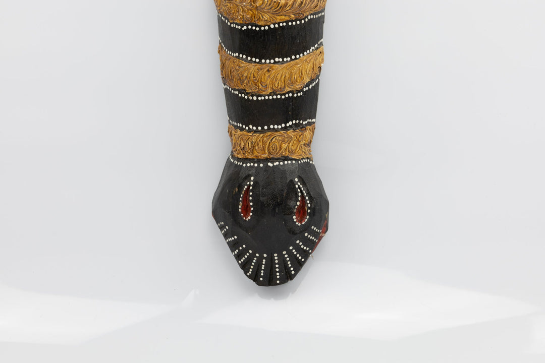 Lower half of horned giraffe wooden mask with dark base, gold trim, and beaded dots