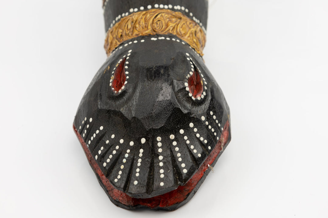 Close-up of giraffe wooden mask snout with red eye inlays and white bead details