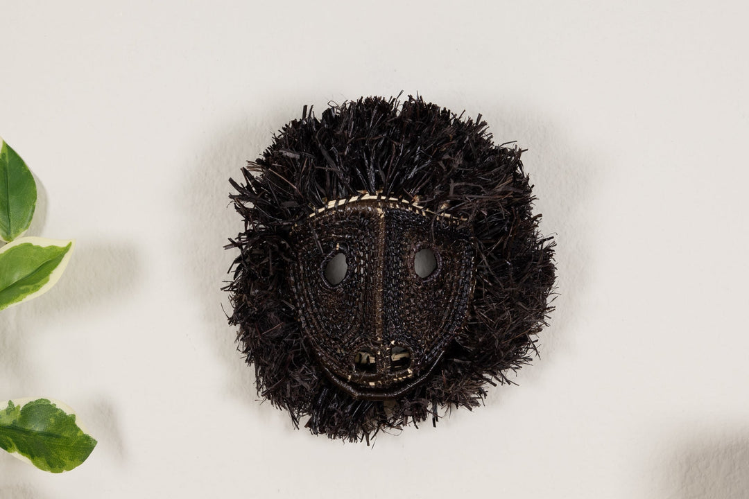 Black howler monkey face mask with round eye cutouts and woven textured surface