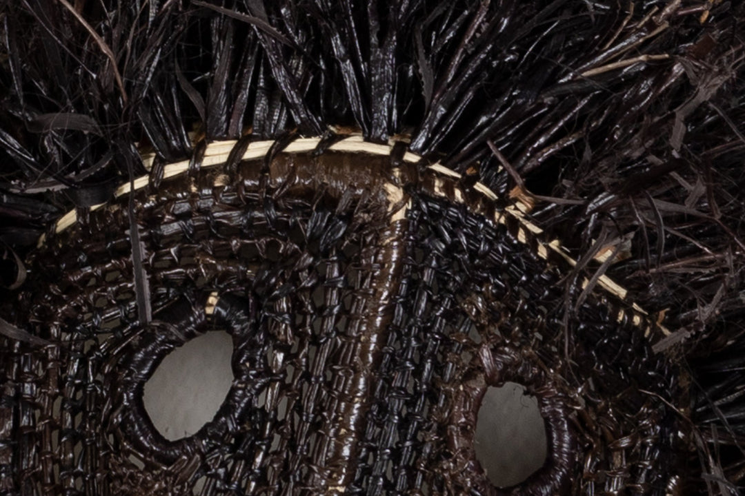 Decorative black animal mask with carved muzzle and open mouth details