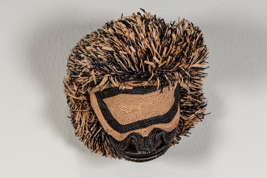 Spider monkey face mask front view with black eye shapes and tan patterned fabric