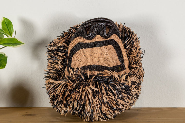 Spider monkey face mask side close-up with textured brown fringe and dark outline
