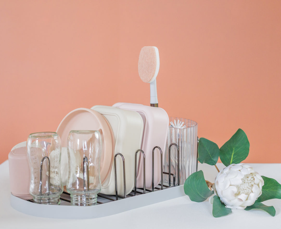 Countertop dish drying rack with gold frame, glassware slots, and white bottle brush