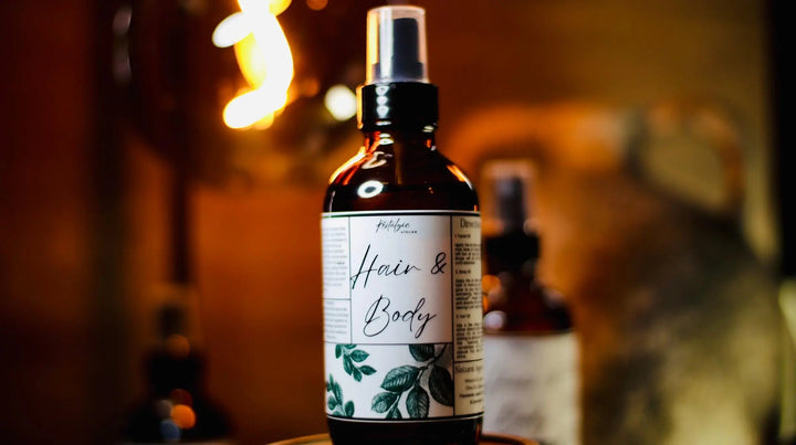 All-natural hair and body oil spray bottle with white label and green leaf print