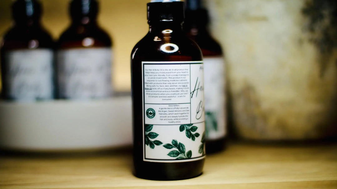 All-natural hair and body oil bottle with back label and green botanical accents