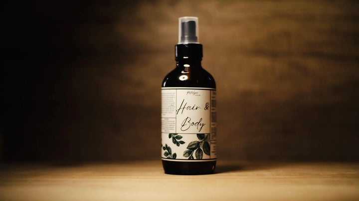 All-natural hair and body oil bottle with pump sprayer and front botanical label