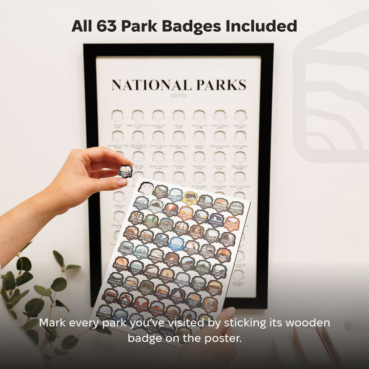 Hand placing a wooden park badge onto a national parks tracker poster in frame
