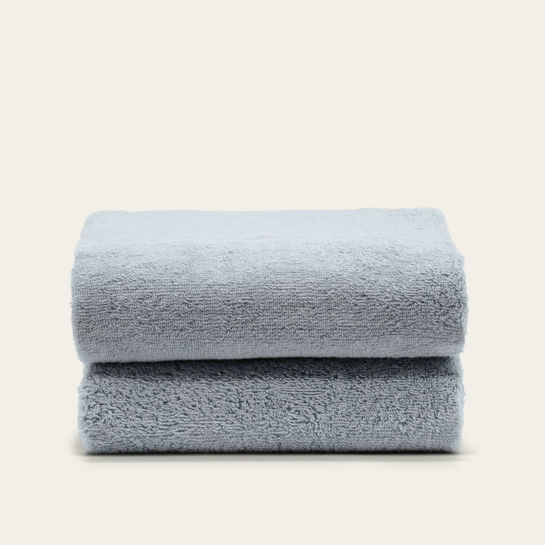 Light blue cotton towels folded stack with smooth, plush pile