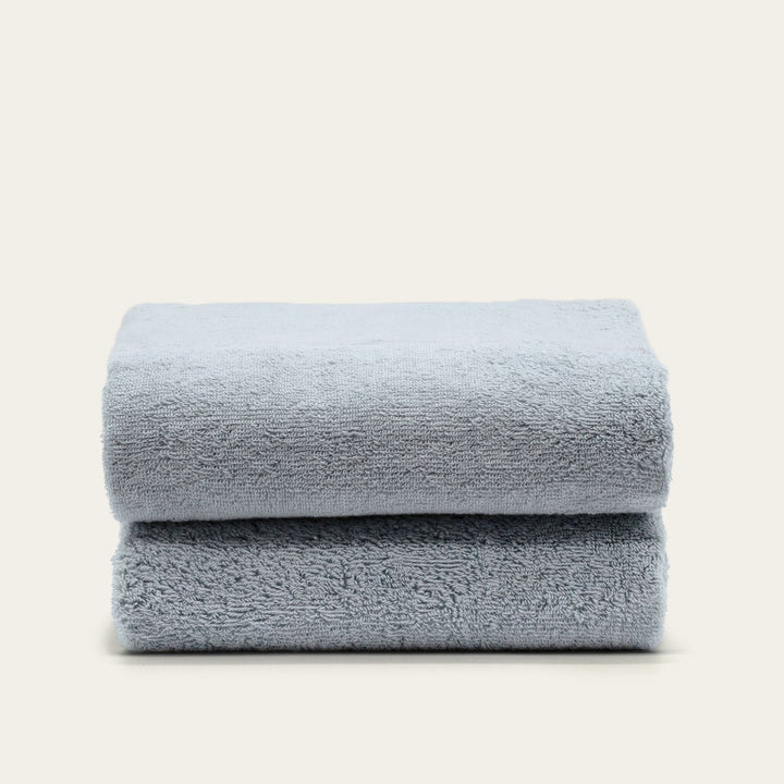 Light blue cotton towels folded stack with smooth, plush pile
