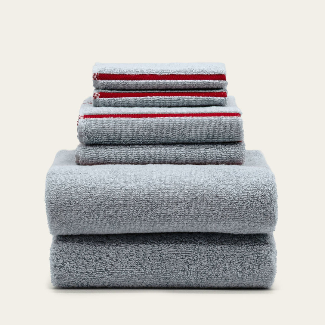 Stack of dark gray cotton bath towels, folded and neatly layered.