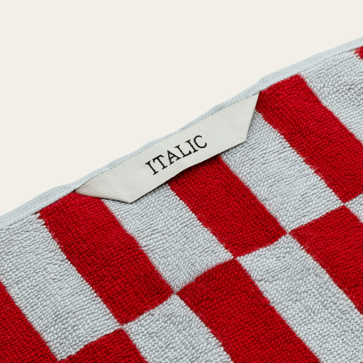 Red and white check cotton towel with fabric label reading ITALIC.
